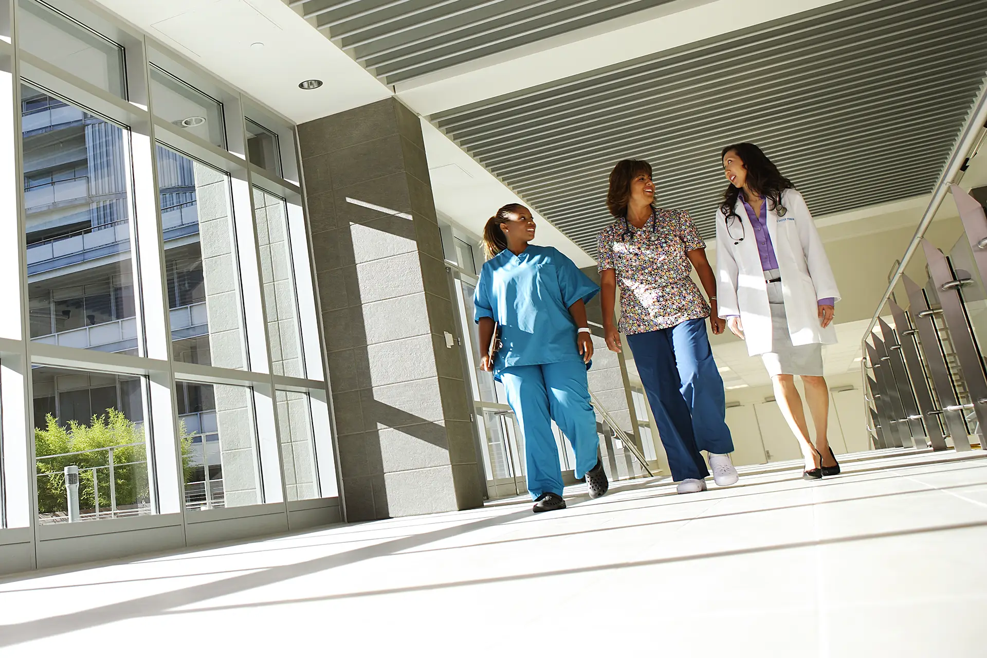 Nurses and Doctor walking in hospital hall