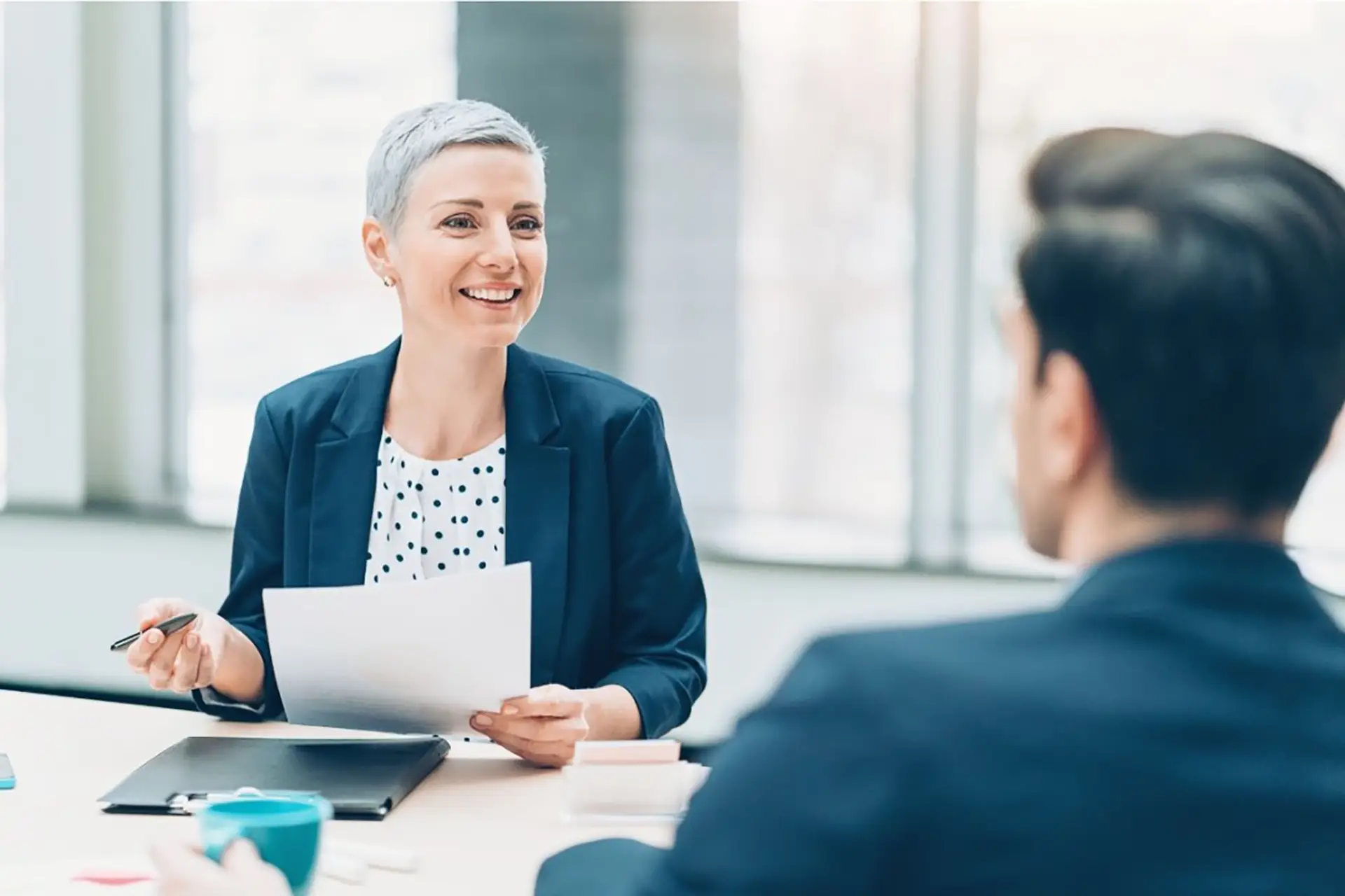 Businessman woman holding papers talking to colleague