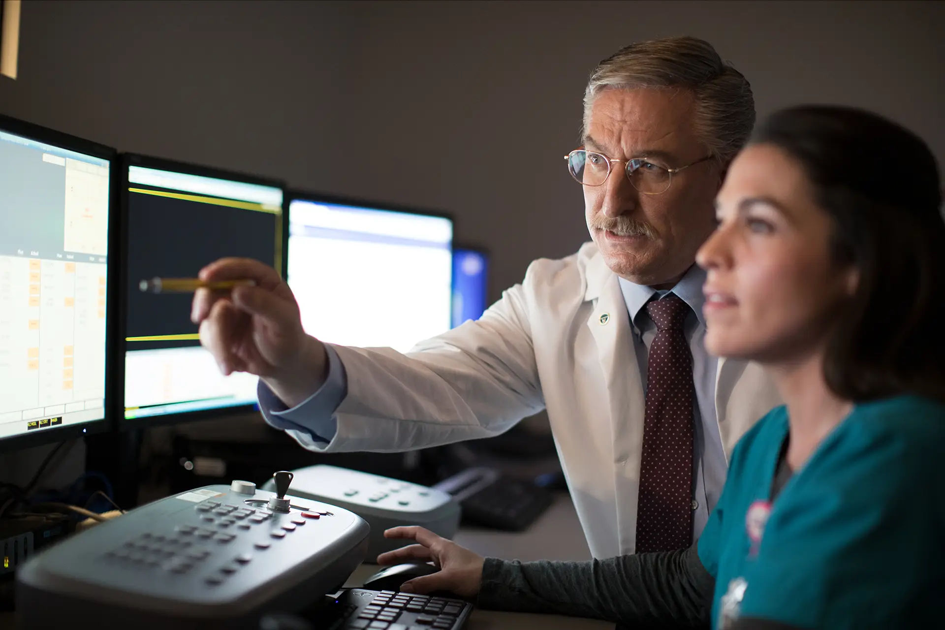 Doctor and nurse looking at charts on computer