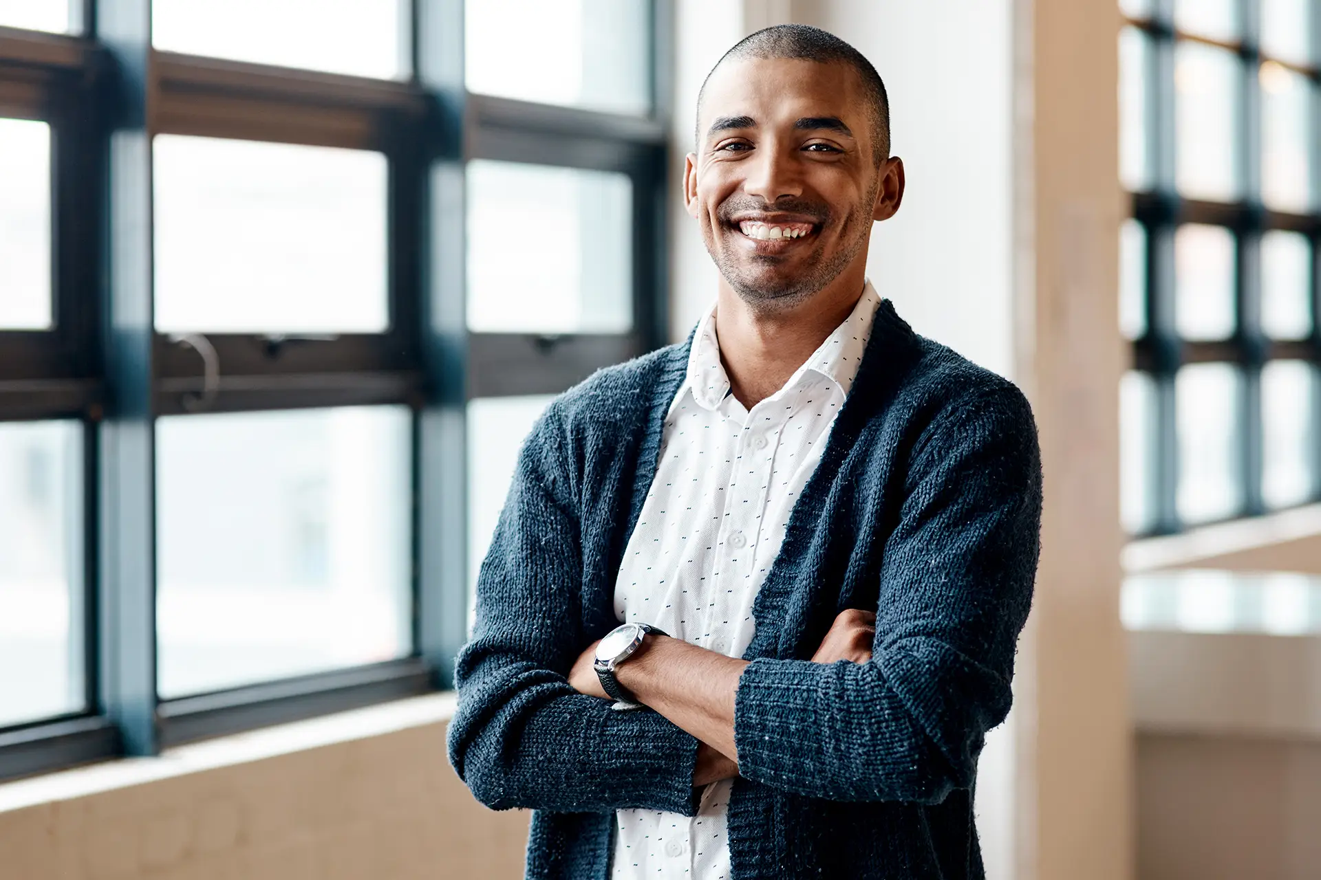 Man smiling with arms crossed